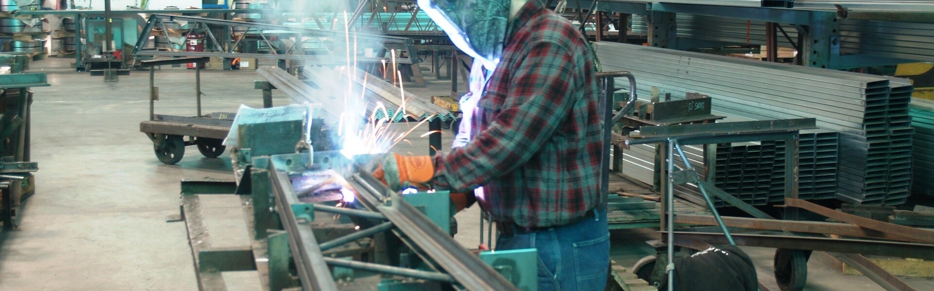 worker welding a steel truss arm